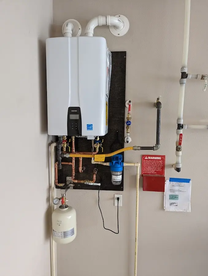 Professional plumber installing copper piping in a Cohasset home